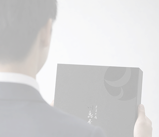 スーツの男性が手土産を持っているイメージ